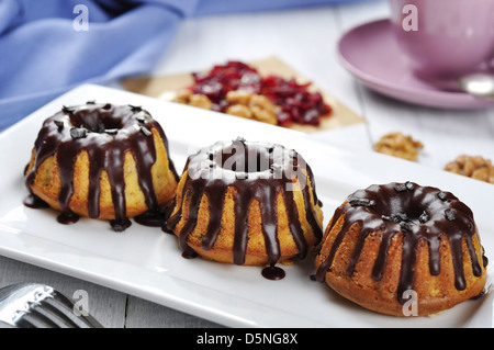 Torta con fuso chokolate ciliegina sul piatto bianco su sfondo di legno Foto Stock