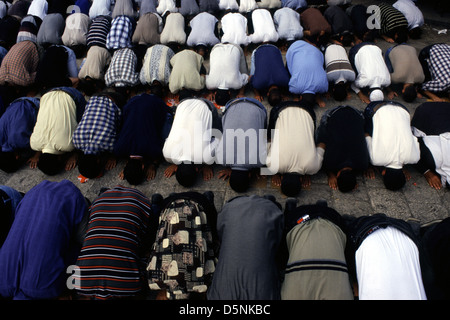 Gli uomini palestinesi si prostrano durante la preghiera di Salah nella Città Vecchia di Gerusalemme Israele Foto Stock