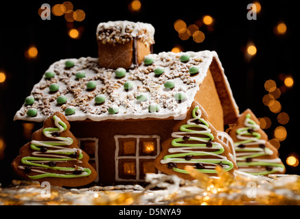 Gingerbread house con luci all'interno, sfondo scuro Foto Stock