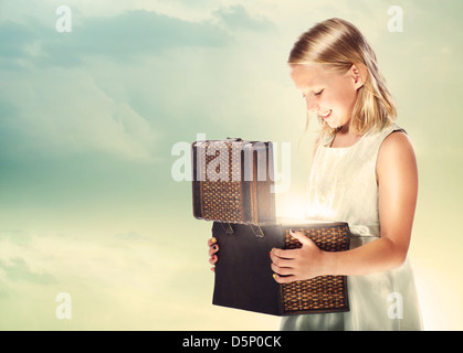 Felice ragazza bionda apertura di una scatola del Tesoro Foto Stock