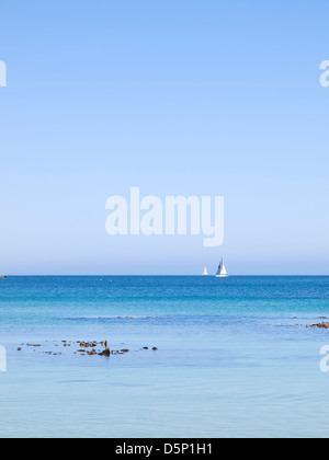 Blue seascape con barca a vela all'orizzonte. La foto è stata scattata in una tranquilla mattina di luglio su una spiaggia in Galizia. Foto Stock