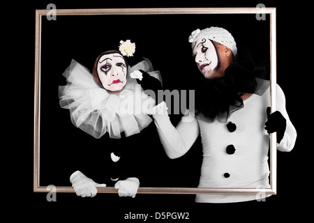 Paio di clown in un telaio, uno sembra triste Foto Stock