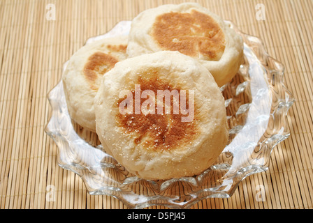 Tre tutto il muffin inglesi su una piastra Foto Stock