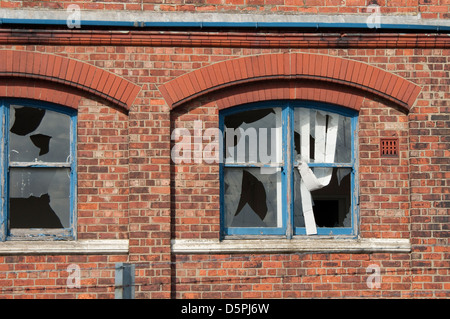 Finestre rotte su edificio abbandonato Foto Stock