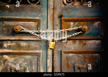 Un vecchio di ferro arrugginito porta bloccata da catene in acciaio Foto Stock