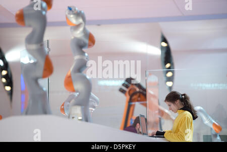 Un dipendente della società KUKA regola il software di un roboter braccio presso la Fiera di Hannover a Hannover, Germania, 07 aprile 2013. Circa 6.500 aziende prendono parte in tutto il mondo più grande fiera del settore Fiera di Hannover (Hannover Messe) dal 08 al 12 aprile 2013. Foto: JOCHEN LÜBKE Foto Stock