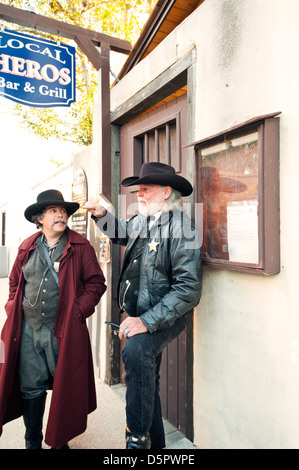 Sant'Agostino Florida, Candida street scene due uomini in costume di fronte a una città bar 'Local Hero's" bar e grill. Foto Stock