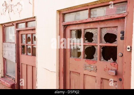 Porte di due vecchie case, con finestre rotte. Foto Stock