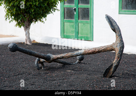 Un monumento di ancoraggio è impostato in un giardino con terreno vulcanico Foto Stock