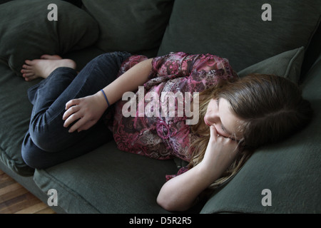 Un 12 anni ragazza sdraiato su un lettino. Foto Stock