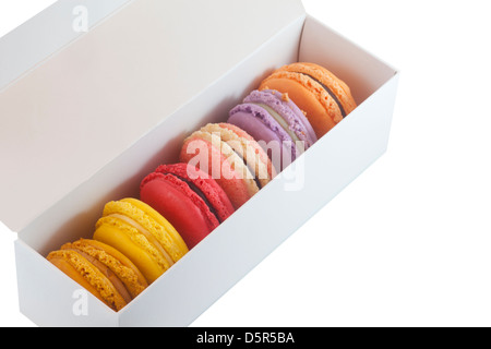 Mezza dozzina di macaron colorati in una scatola regalo, ritagliata su sfondo bianco Foto Stock