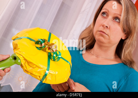 Giovane donna bionda che riceve un dono senza pensieri Foto Stock