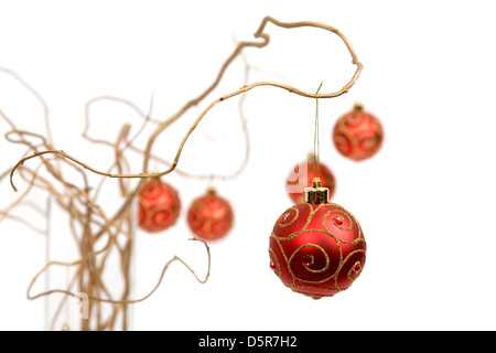 Red christmas baubles appesi da golden rami ricci Foto Stock