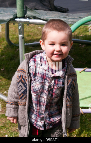 Vestito 3 anno vecchio ragazzo con capelli corti in piedi guardando la telecamera Foto Stock