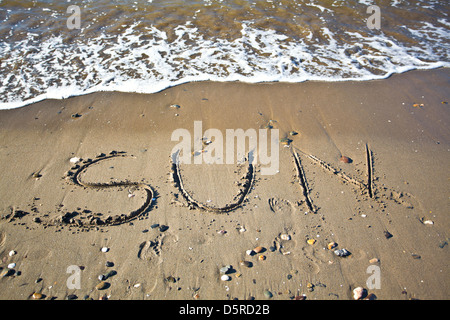 La parola Marbella scritto nella sabbia bagnata in spiaggia Foto Stock