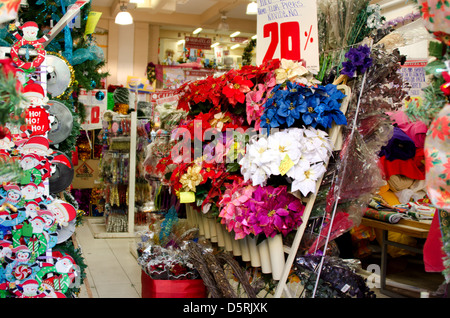 Negozio di vendita sulle decorazioni natalizie, inclusi blue, viola e rosso faux poinsettias, Oaxaca. Messico. Foto Stock