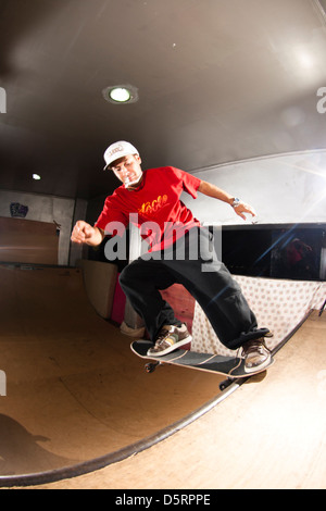 Pro rider Rafael Tramonte 'Pingo' porforming trucchi skateboard in un mini in legno skate park. São Vicente, Brasile. Foto Stock