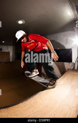 Pro rider Rafael Tramonte 'Pingo' porforming trucchi skateboard in un mini in legno skate park. São Vicente, Brasile. Foto Stock
