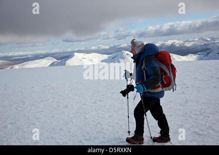 Donna walker sul vertice del Ben Nevis in condizioni di neve con buona visibilità Foto Stock