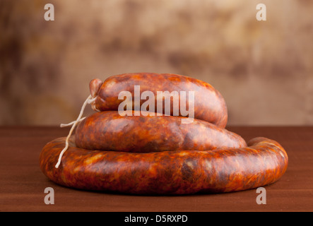 Salame crudo sul tavolo di legno Foto Stock