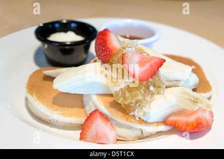 Frittelle di banane fragole a nido d'ape di sciroppo di acero e burro Closeup Foto Stock