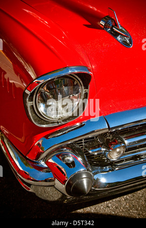 Il faro e la estremità anteriore chrome dettagli su una custom dipinte di rosso 1957 Chevy 150 carro Foto Stock