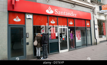 Coppia giovane persone usando il Santander ATM per ottenere contanti su Queen Street nella città di Cardiff Wales UK KATHY DEWITT Foto Stock