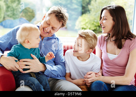 Famiglia sat insieme a casa Foto Stock