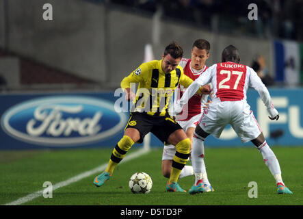 Dortmund's Mario Götze (L) e Niklas Moisander (C) e Jody Lukoki di Amsterdam si contendono la palla durante la UEFA Champions League gruppo D partita di calcio Ajax Amsterdam vs. Borussia Dortmund presso l'Arena di Amsterdam in Amsterdam, Paesi Bassi, 21 novembre 2012. Foto: Federico Gambarini/dpa Foto Stock