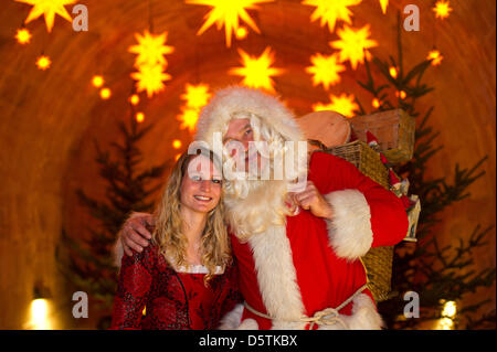 Santa Claus (Richard Riesel) e la Belle (Nadja Tannert) posa per fotografie durante una sessione di stampa del xvii storico-romantico mercatino di Natale a Koenigstein fortezza nel Koenigstein, Germania, 27 novembre 2012. In cima alla collina di tabella il mercatino di Natale sarà aperto il 01 dicembre 2012. Foto: Arno Burgi Foto Stock