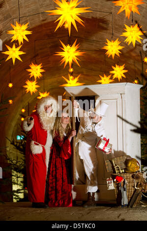 Santa Claus (Richard Riesel, L-R), La Belle (Nadja Tannert) e giocoliere 'Ben aus Schrankreich' (Benjamin Loeffler) posa per fotografie durante una sessione di stampa del xvii storico-romantico mercatino di Natale a Koenigstein fortezza nel Koenigstein, Germania, 27 novembre 2012. In cima alla collina di tabella il mercatino di Natale sarà aperto il 01 dicembre 2012. Foto: Arno Burgi Foto Stock