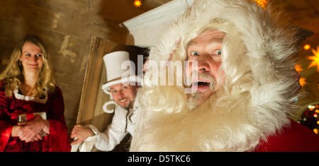 Santa Claus (Richard Riesel, R), La Belle (Nadja Tannert) e giocoliere 'Ben aus Schrankreich' (Benjamin Loeffler) posa per fotografie durante una sessione di stampa del xvii storico-romantico mercatino di Natale a Koenigstein fortezza nel Koenigstein, Germania, 27 novembre 2012. In cima alla collina di tabella il mercatino di Natale sarà aperto il 01 dicembre 2012. Foto: Arno Burgi Foto Stock