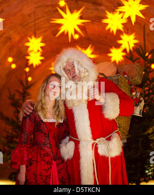 Santa Claus (Richard Riesel) e la Belle posa per fotografie durante una sessione di stampa del xvii storico-romantico mercatino di Natale a Koenigstein fortezza nel Koenigstein, Germania, 27 novembre 2012. In cima alla collina di tabella il mercatino di Natale sarà aperto il 01 dicembre 2012. Foto: Arno Burgi Foto Stock