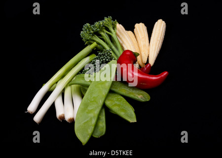 Peperoncino, broccoli, baby porro, baby mais e gestire tout su sfondo nero Foto Stock