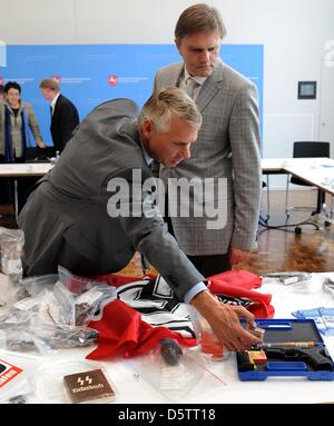 Bassa Sassonia Ministro degli interni di Uwe Schuenemann (R) e Hannover è presidente di polizia Axel Brockmann (L) stand di fronte NPD cartelloni, sequestrati armi e materiale di propaganda dopo una conferenza stampa presso il Ministero degli Interni ad Hannover, Germania, 25 settembre 2012. Bassa Sassonia vietato il più importante neo-nazi gruppo dello stato tedesco. Dal 2008, il gruppo aveva effettuato Foto Stock