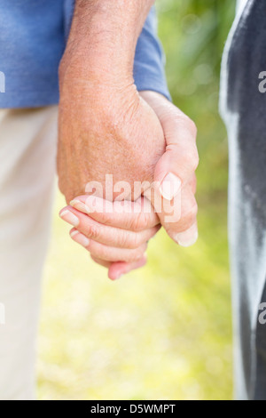 Coppia di anziani tenendo le mani all'aperto Foto Stock