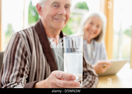 Uomo più anziano di prendere il farmaco in acqua Foto Stock