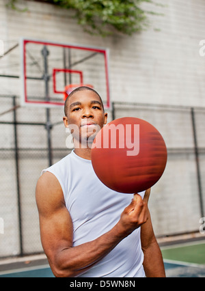 Uomo di pallacanestro di filatura sul dito Foto Stock