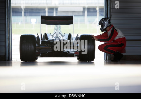 Racer lavorando su auto in garage Foto Stock