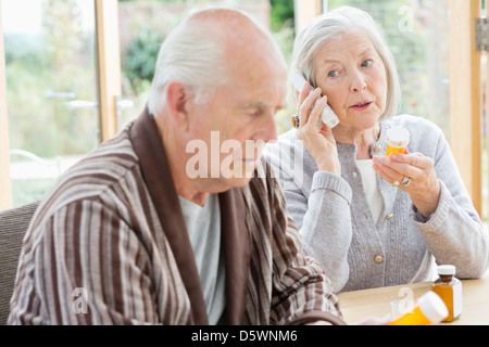 Donna anziana con farmaci parlando al telefono Foto Stock