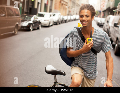 L'uomo equitazione Bicicletta su una strada di città Foto Stock