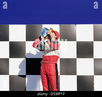 Racer kissing trofeo alla cerimonia di premiazione Foto Stock