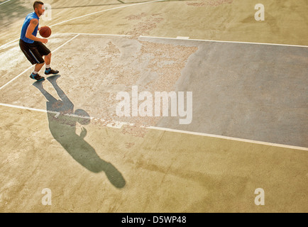 L'uomo giocare a basket su corte Foto Stock