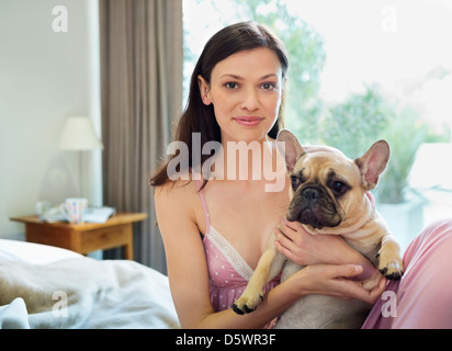 Donna petting cane nel letto Foto Stock