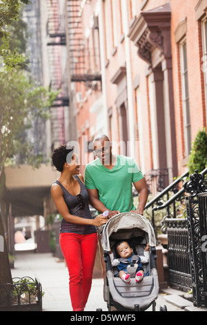 Famiglia a camminare insieme sulla via della città Foto Stock