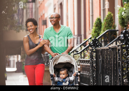 Famiglia a camminare insieme sulla via della città Foto Stock