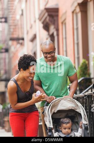 Famiglia a camminare insieme sulla via della città Foto Stock