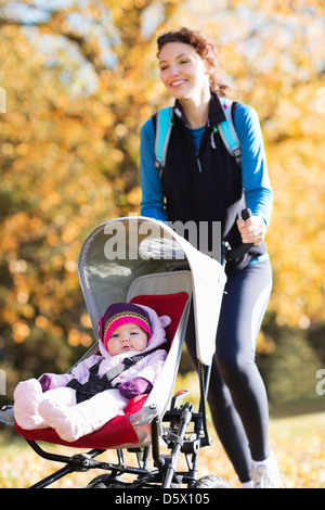 Donna in corsa con il passeggino in posizione di parcheggio Foto Stock