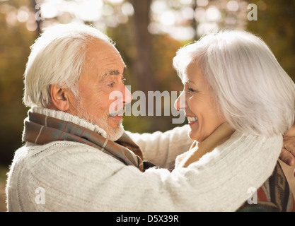 Coppia di anziani abbracciando all'aperto Foto Stock