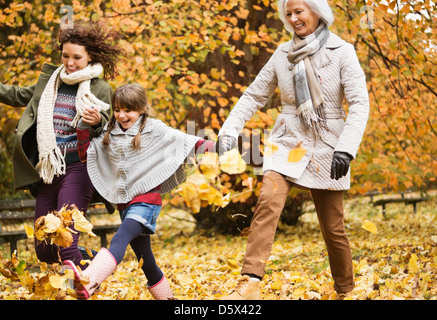 Tre generazioni di donne in riproduzione in foglie di autunno Foto Stock